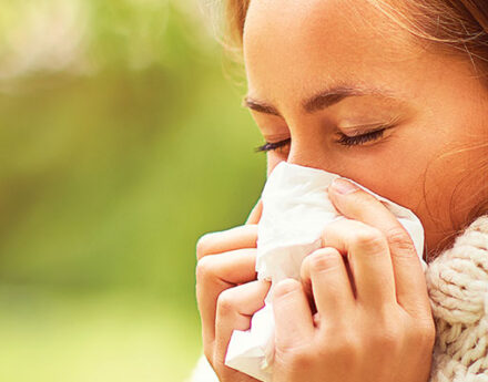 Eine Frau, die ins Taschentuch niest