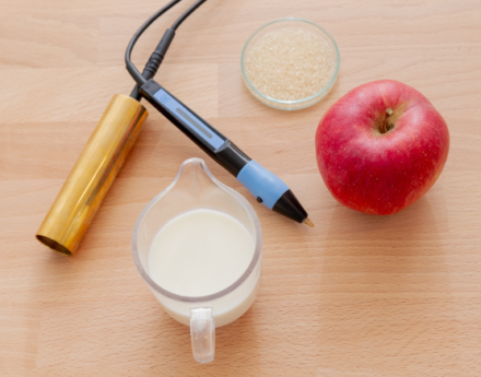 Petrischale, Milch, Apfel und Gerät für Elektroakupunktur nach Voll (EAV)